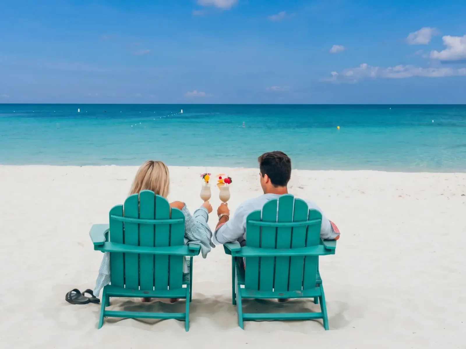 Couple relaxing beside the clear water of Eagle Beach